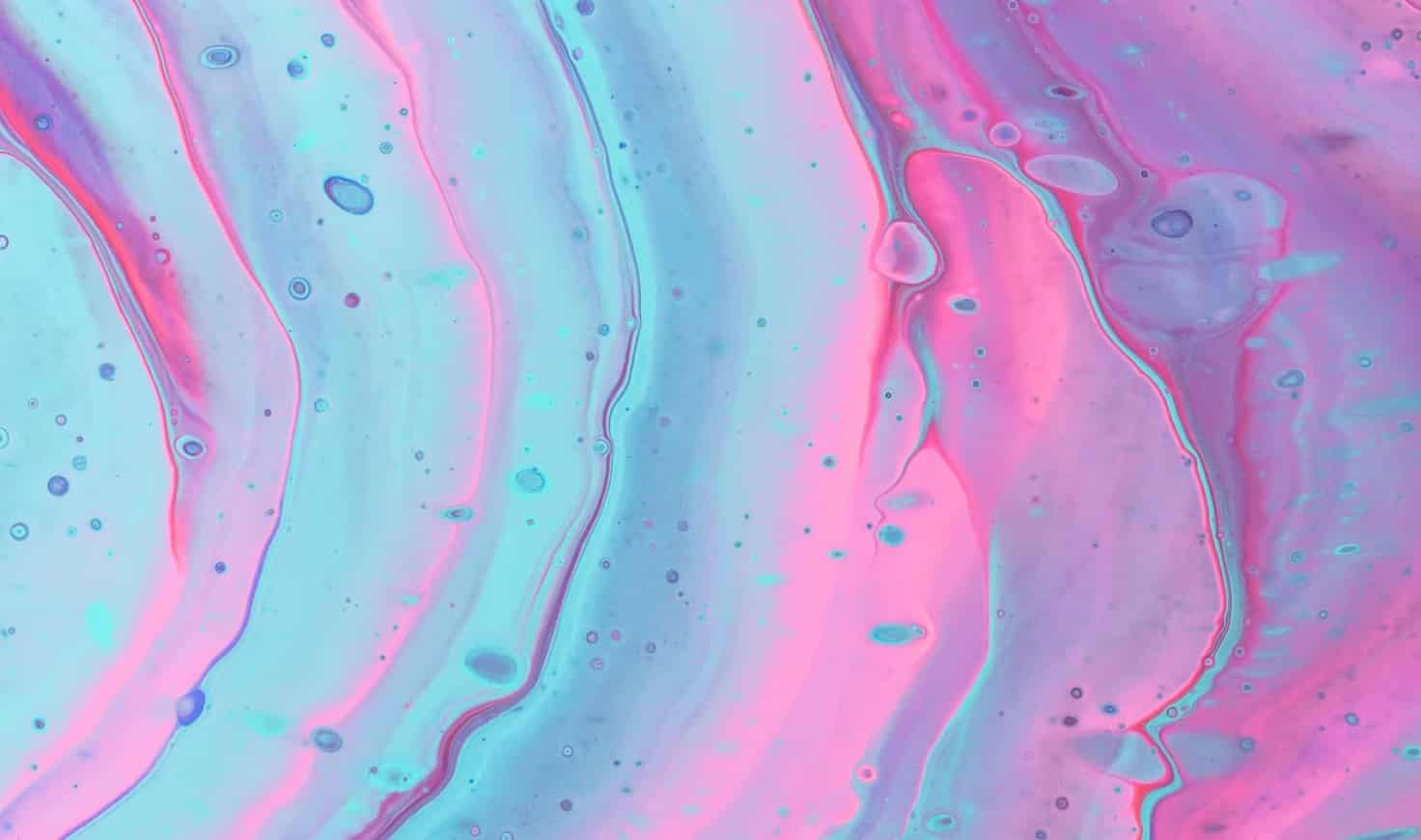 Iridescent ripples of a bright blue and pink liquid